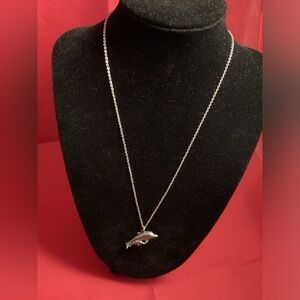 Silver tone gray dolphin pendant on a silver tone chain